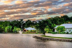 widok na jezioro z domem i fontanną w obiekcie Blue Lagoon Villas w mieście Trinity Beach