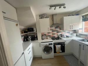 a small kitchen with a washing machine in it at Double room in a cul de sac area in Wellingborough