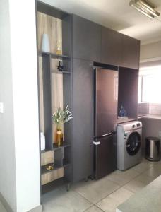 a kitchen with a refrigerator and a washing machine at 15 Elizabeth Place - Luxury Apartments, Free Wi-Fi in Midrand
