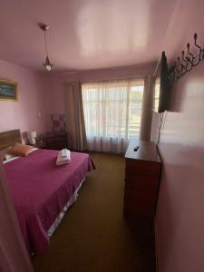 a bedroom with a purple bed and a window at Hospedaje Rios in Osorno