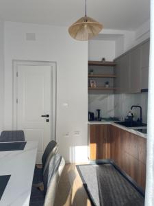 a kitchen with a table and some chairs in a room at Sunny City Center Apartment in Lezhë +3 photos
