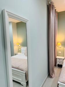 a mirror in a bedroom with a bed at Colosseo House in Rome