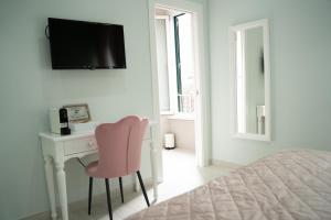 a bedroom with a desk and a pink chair at Colosseo House in Rome