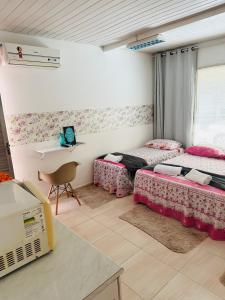 um quarto com 2 camas e uma mesa com um computador portátil em Hostel das Flores em Belém