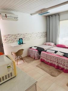 a room with two beds and a table with a laptop at Hostel das Flores in Belém
