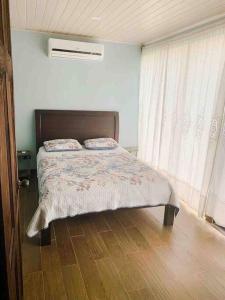 a bedroom with a bed with a wooden floor at Casa del Árbol in Quepos +46 photos