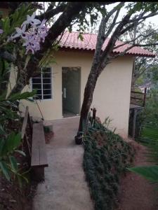 une petite maison avec une passerelle menant à une porte dans l'établissement Flor da serra, à Santo Antônio do Pinhal