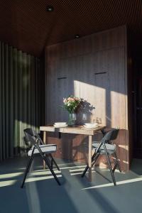 una mesa con dos sillas y un jarrón de flores. en Spreeapartment LUNA en Berlín