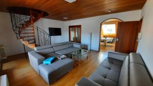 ein Wohnzimmer mit einem Sofa und einer Treppe in der Unterkunft Black Stone Apartments - Lörrach in Lörrach