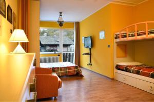 a bedroom with yellow walls and a bunk bed at 5 Minuti da Monterosa Ski, Piccolo Cottage in Gressoney-la-Trinité