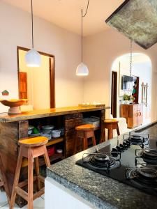 cocina con fogones y encimera con taburetes en Casa da Cosmira, en Trancoso