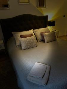 1 cama grande con almohadas y toalla blanca en Roman House Borsa, en Borşa