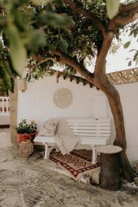 a white bench under a tree next to a tree at Villa Soluna in Vélez-Málaga