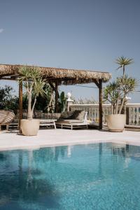 a pool at a resort with a gazebo and palm trees at Villa Soluna in Vélez-Málaga