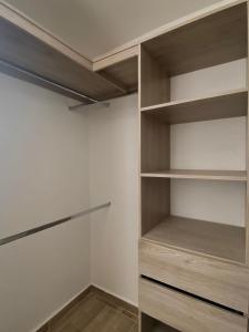 a walk in closet with white walls and wooden shelves at Conjunto Speranza in Puerto Colombia