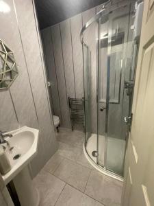 a bathroom with a shower and a sink at Femros Apartments, 15mins to city center. in Smethwick