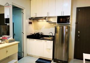 a kitchen with a stainless steel refrigerator and white cabinets at Palawan 1BR Summer Get-away Deluxe with Balcony FREE Pool and Gym - T2 6 Diamond in Puerto Princesa City