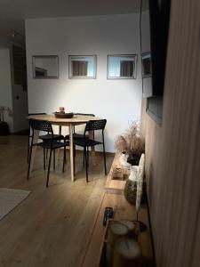 Un comedor con mesa y sillas en ROMAN Residence Apartment, en Borşa 20 fotos más