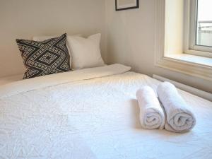 a white bed with towels on it with a window at Charming and spacious apartment in Oslo