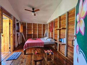 Lighthouse Hotel and Spa, Little Corn island, Nicaragua في جزيرة ليتل كورن: غرفة نوم بسرير في غرفة بجدران خشبية