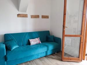 a blue couch with a pillow on it in a room at Beach House in Platamona