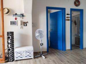 a room with a blue door and a fan at Beach House in Platamona