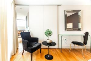 a living room with two chairs and a table and a mirror at Modern City Apartments in London