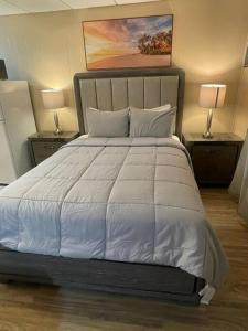 a bedroom with a large white bed with two lamps at Unforgettable Stay in Orlando 1 in Orlando