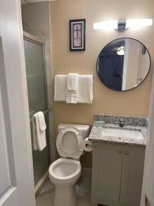 a bathroom with a toilet and a sink and a mirror at Unforgettable Stay in Orlando 1 in Orlando