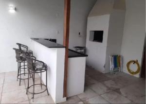 eine Küche mit einer Theke und Hockern in einem Zimmer in der Unterkunft Pousada Claudia e Juliano in São Gabriel