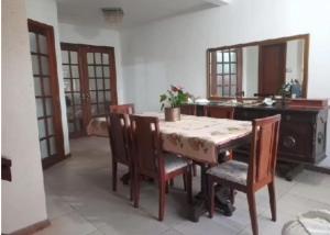 jadalnia ze stołem i krzesłami oraz kuchnia w obiekcie Pousada Claudia e Juliano w mieście São Gabriel