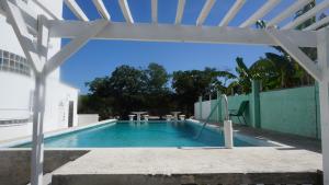einen Außenpool mit einer weißen Pergola in der Unterkunft See Belize RELAXING Sea View Studio with Infinity Pool & Overwater Deck in Belize City