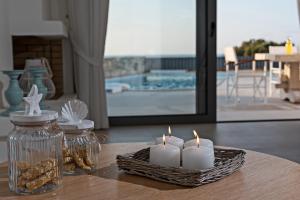 a table with candles and a wicker basket with cookies at Lygaries Villas in Panormos Rethymno