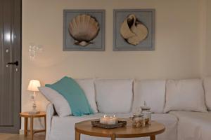 una sala de estar con un sofá blanco con velas sobre una mesa en Lygaries Villas en Panormos Rethymno