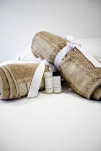 a pile of towels on a bed with a ribbon at Apartahotel La Arboleda HC in Manizales