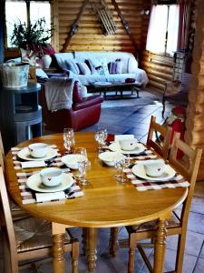 a wooden table with plates and glasses on it in a living room at Chalet con vistas al lago Matemale en Les Angles in Les Angles