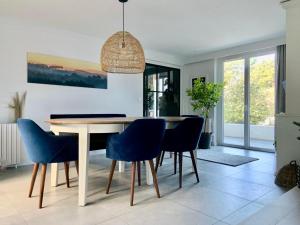 a dining room with a table and blue chairs at Villa Vagues de Vie - 4 Étoiles in Labenne