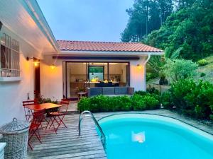 uma casa com uma piscina e um pátio em Villa Vagues de Vie em Labenne