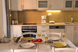 a kitchen with a table with glasses of wine at Lygaries Villas in Panormos Rethymno