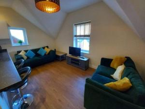 uma sala de estar com dois sofás e uma televisão em Roomy Penthouse 2 double bed apartment - Spacious - Central Beeston - Free secure parking - em Nottingham