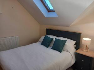 a bedroom with a white bed with blue pillows at Roomy Penthouse 2 double bed apartment - Spacious - Central Beeston - Free secure parking - in Nottingham