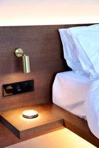 梅加尼西島的住宿－Amphitheatro Boutique Hotel，一间卧室配有一张床和一张桌子上的闹钟