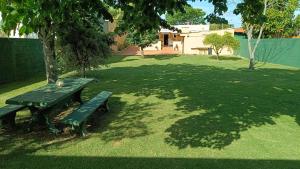 a green park bench sitting in the middle of a yard at Casa Independiente en Punta Gorda in Montevideo