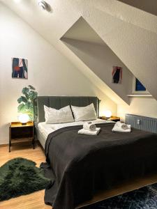 ein Schlafzimmer mit einem Bett mit zwei Handtüchern darauf in der Unterkunft Oasis Appart - Wohnen am Elbtal - Balkon - Netflix - Tiefgarage in Dresden