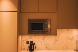 a microwave on the wall of a kitchen at THE CLOSEST building to Burj Khalifa with Fountain View in Address Opera Residence in Dubai