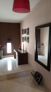 a living room with a mirror and a table at Infinit Home Duplex entero in Termas de Río Hondo