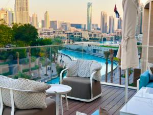 a balcony with chairs and a view of a city at THE CLOSEST building to Burj Khalifa with Fountain View in Address Opera Residence in Dubai