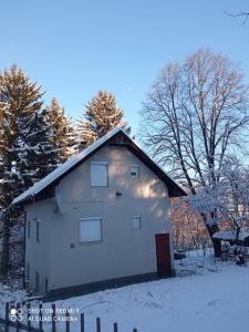 a white building in the snow with trees at Bosnia GCC in Vinogradi