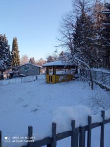 a snow covered yard with a fence and a building at Bosnia GCC in Vinogradi