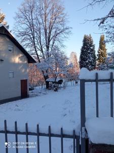 a fence covered in snow next to a house at Bosnia GCC in Vinogradi
